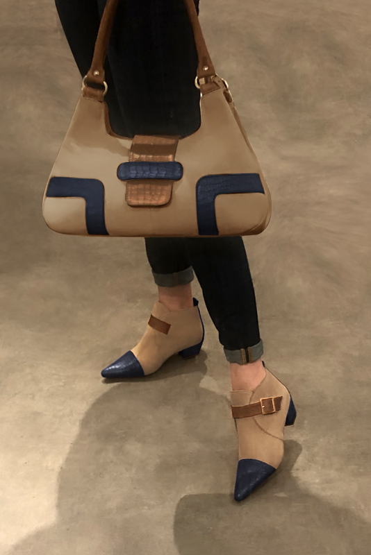 Women's navy blue, tan beige and caramel brown elegant ankle boots, with buckles at the front. Tapered toe. Low cone heels - Worn view